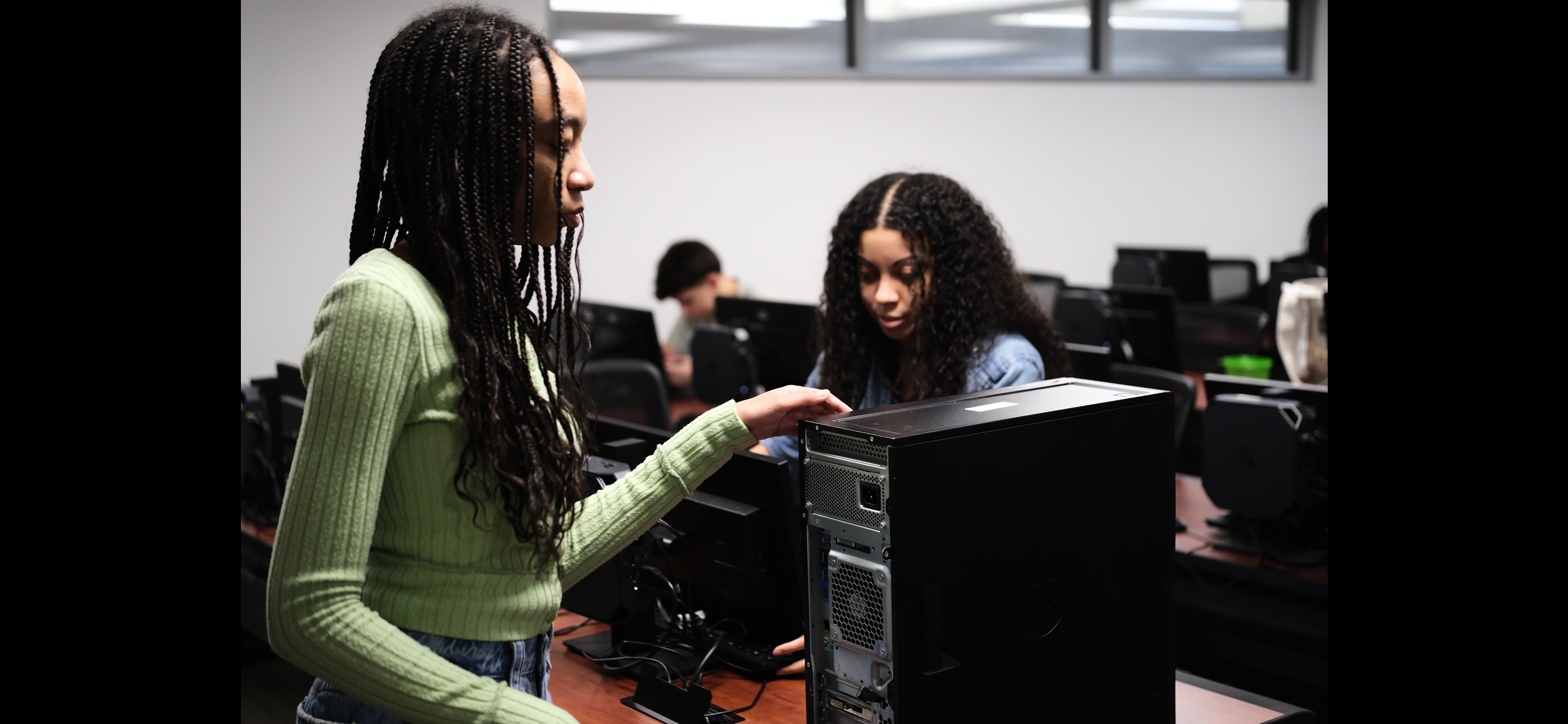 Students examining graphics cards at a workbench