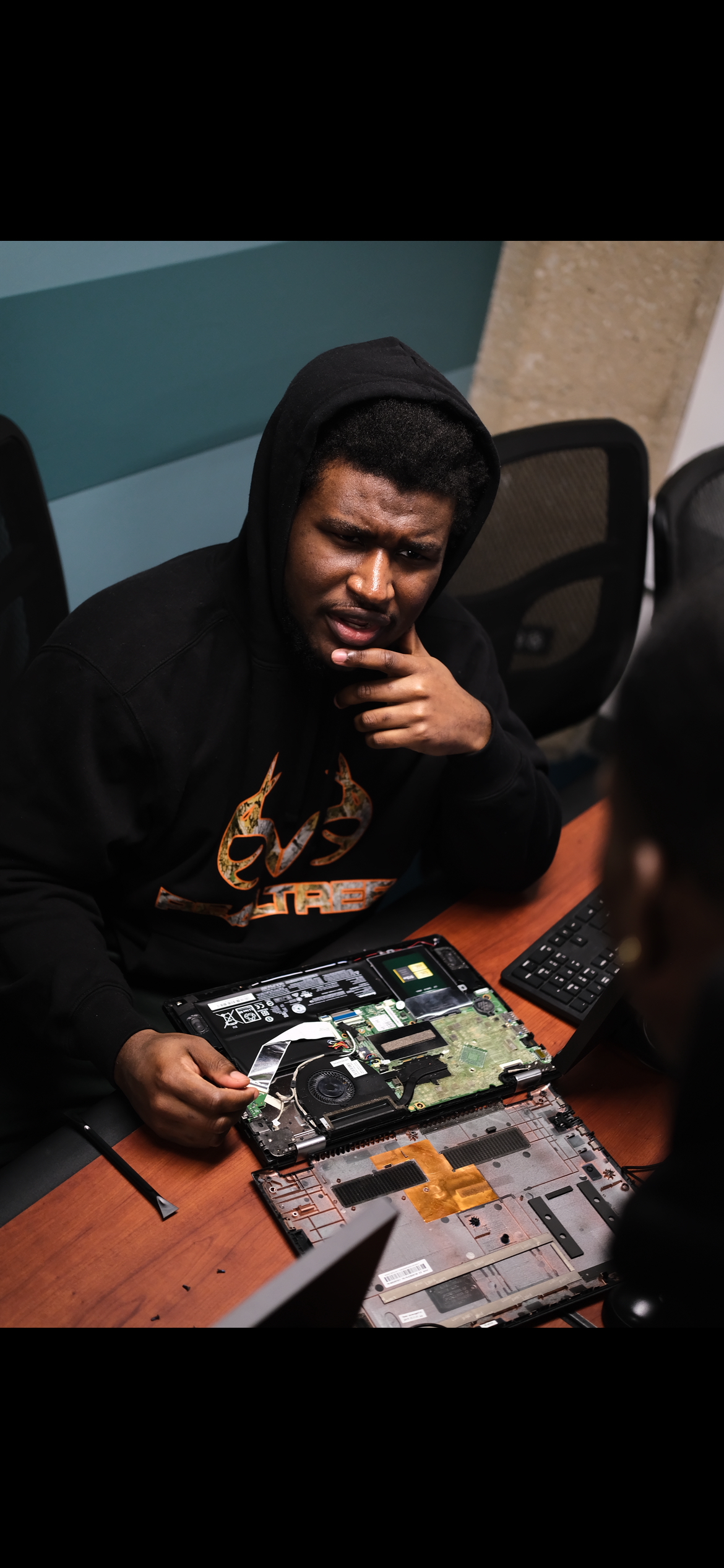 Three female students gathered around an open PC case
