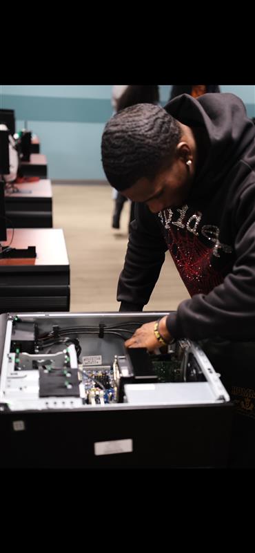 Student leaning over an open desktop case
